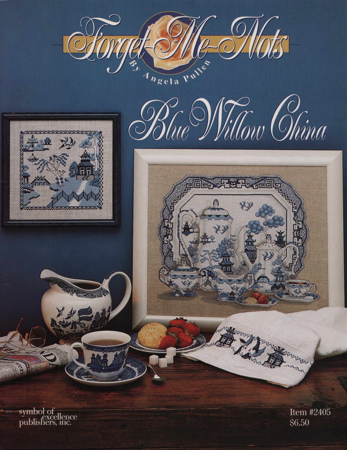 Cover of a 'Forget-Me-Nots' needlework pattern by Angela Butler titled 'Blue Willow China,' showing framed blue-and-white cross stitch china designs above a styled table scene with a teacup, pitcher, cookies, strawberries, and a folded white cloth with blue embroidery.