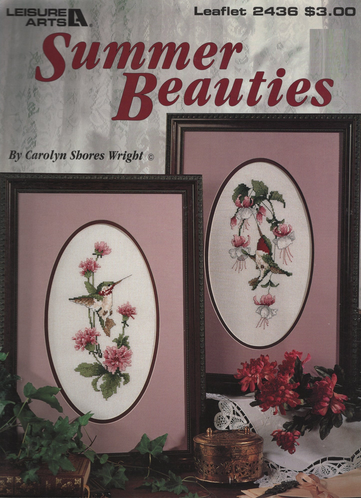 Cover of a Leisure Arts 'Summer Beauties' cross stitch leaflet by Carolyn Shores Wright, showing two framed floral and hummingbird designs on a pink-toned background with decorative flowers and foliage.