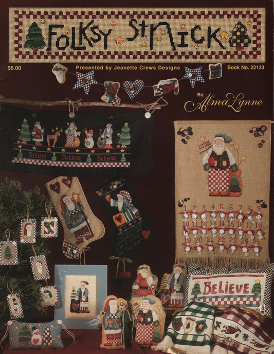 A vintage cross-stitch pattern book cover titled 'Folksy St. Nick' by Alma Lynne, showing multiple festive stitched designs including stockings, ornaments, a Santa figure, and pillows. 22133