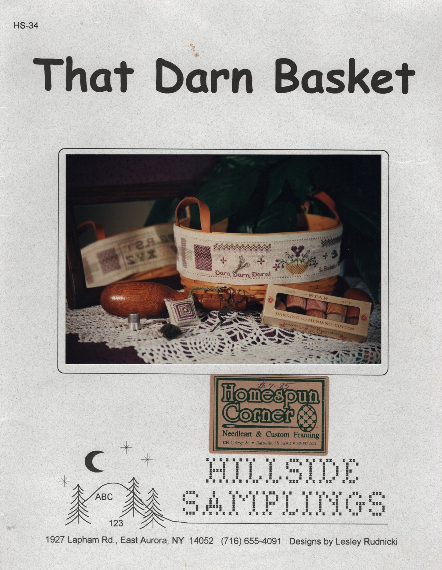 Front cover of a needlework sampler cross stitch pattern titled "That Darn Basket" from Hillside Samplings, showing a decorated basket and sampler items HS-34